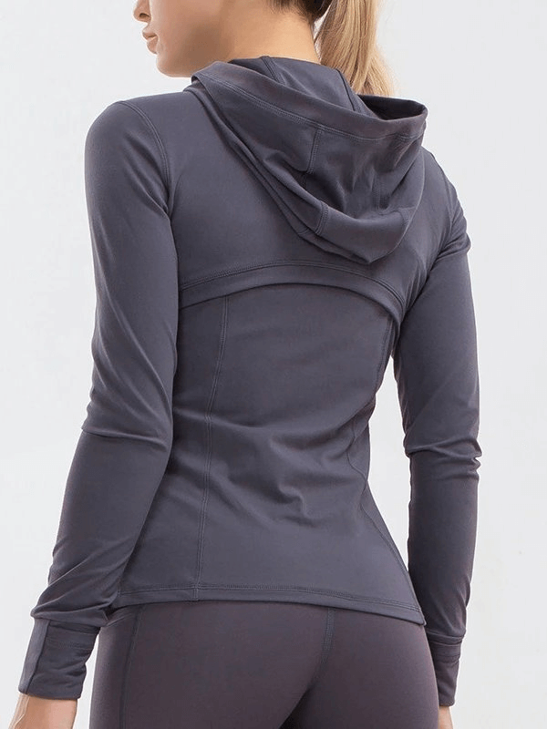 Woman wearing a long-sleeved quick-drying sports shirt with a hood, perfect for yoga. Back view emphasizes stretch and fit.